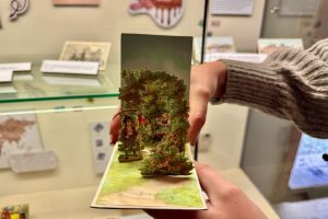 felia-einhorn-präsentiert-klapp-postkarte-aus-der-postkartenausstellung-c-museumsdorf-hoesseringen